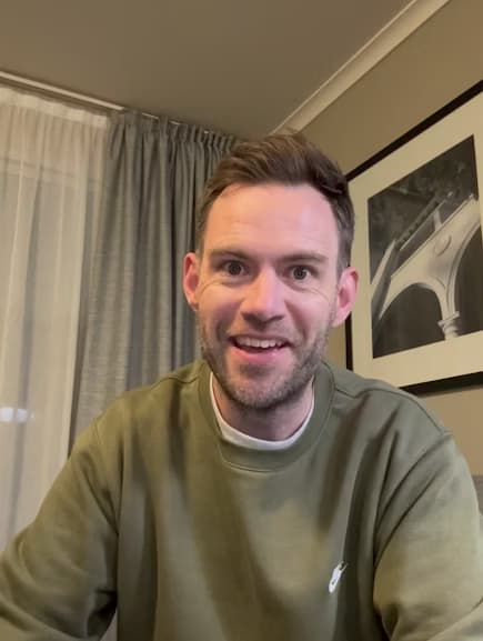 Kyle at home, in front of a framed photograph