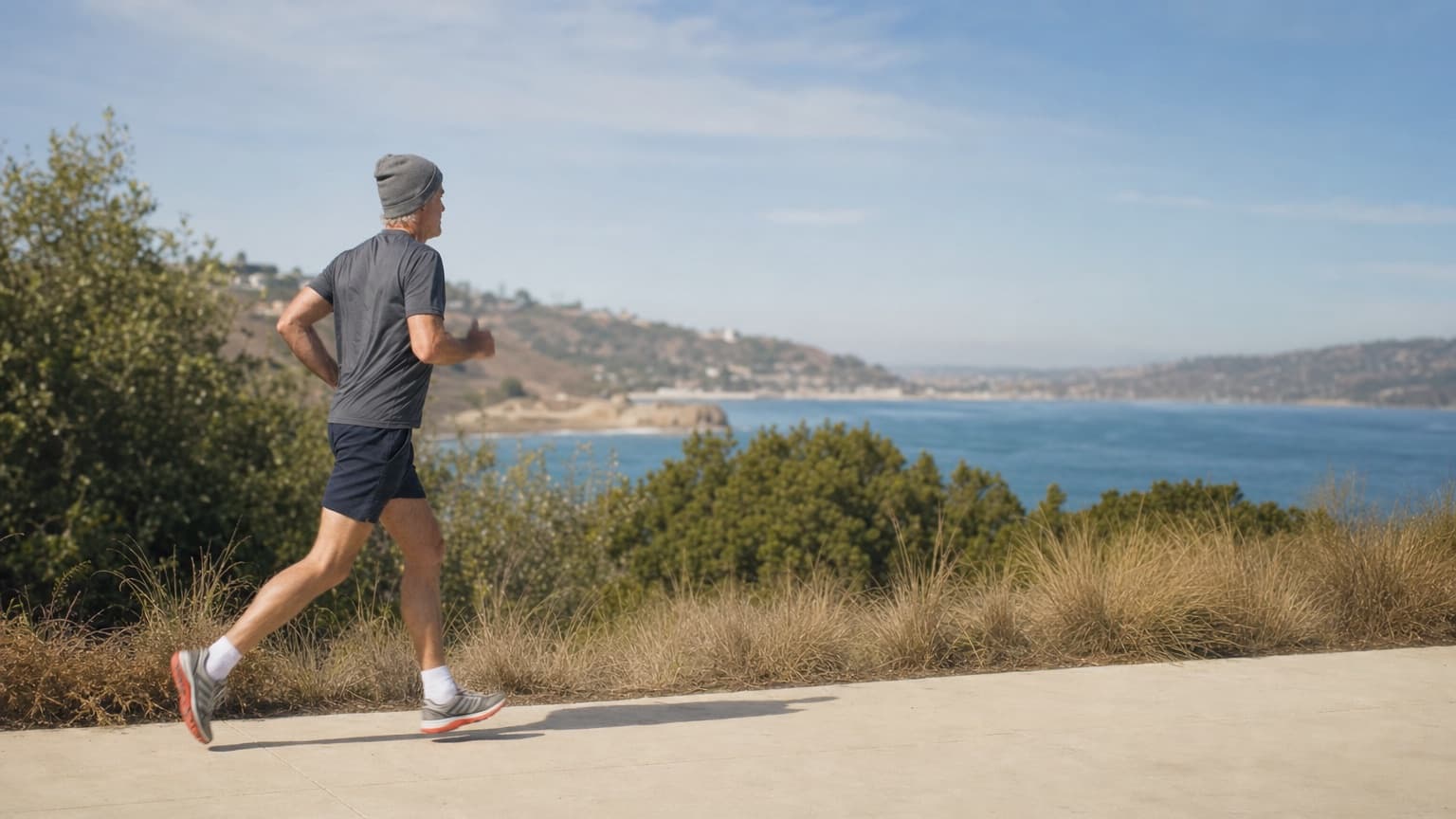 A man running along a coastal path above the sea